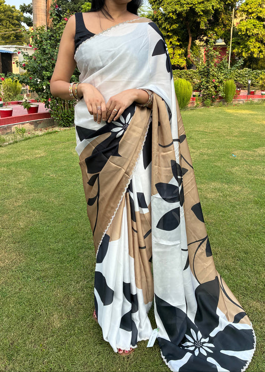 Woman wearing a black and white saree with a garden background