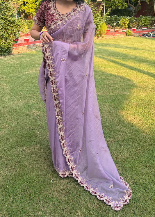Woman in a lavender saree with a green outdoor background