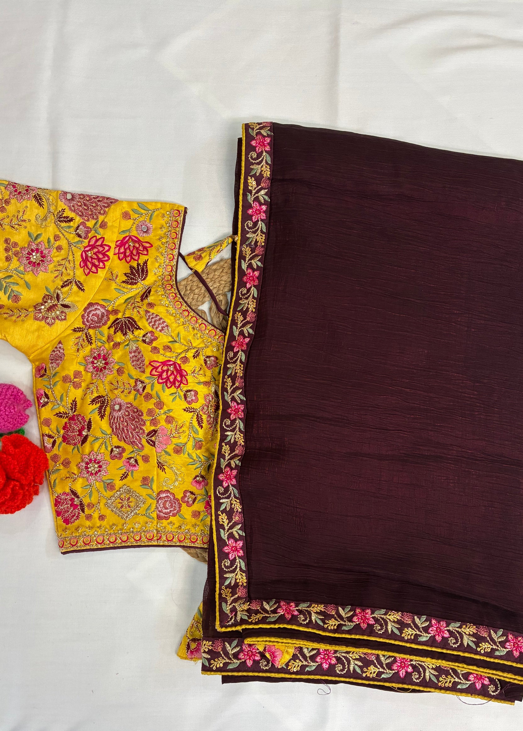 Brown and yellow traditional outfit with floral embroidery on a white background