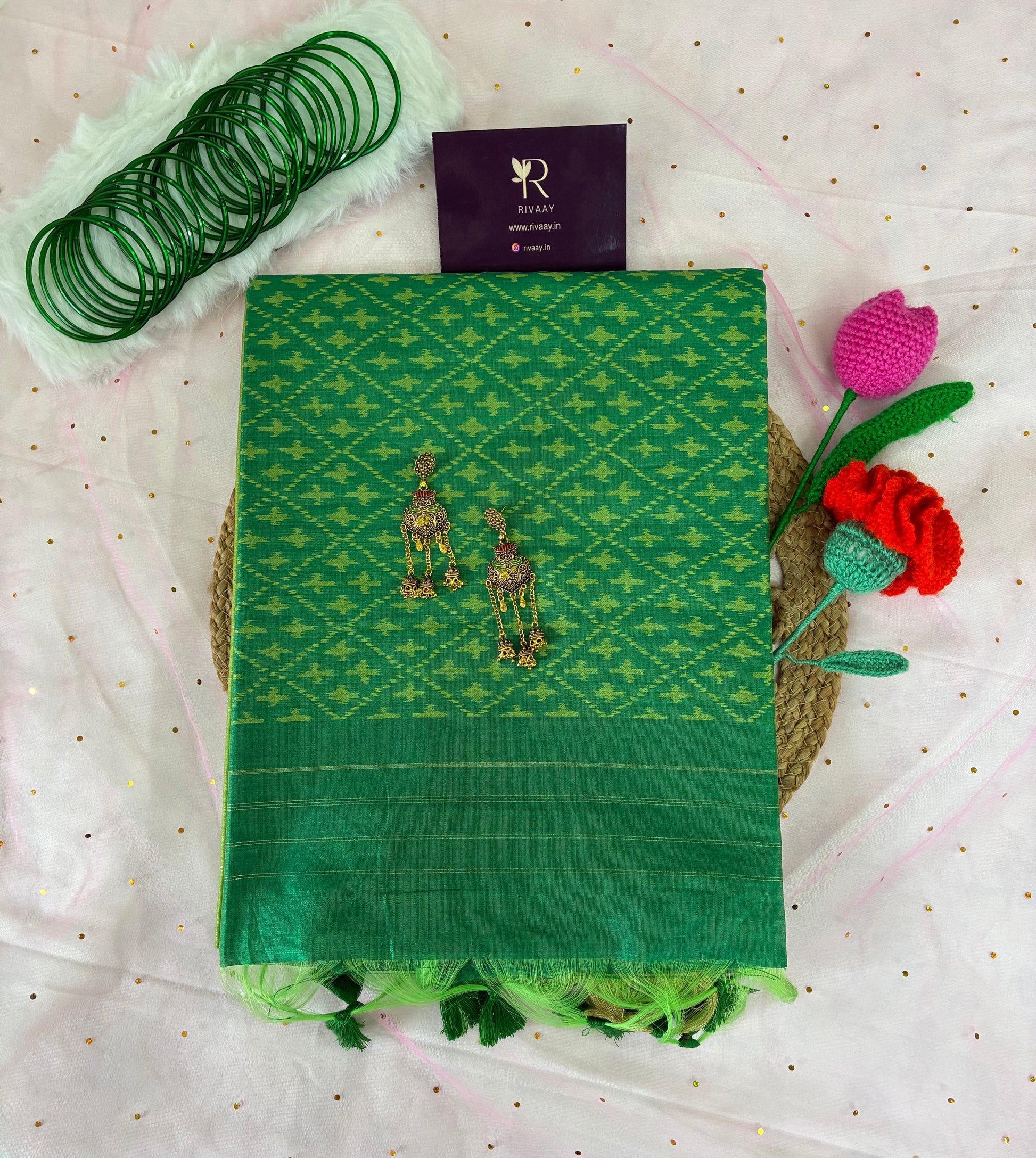 Green fabric with embroidery on a white textured background