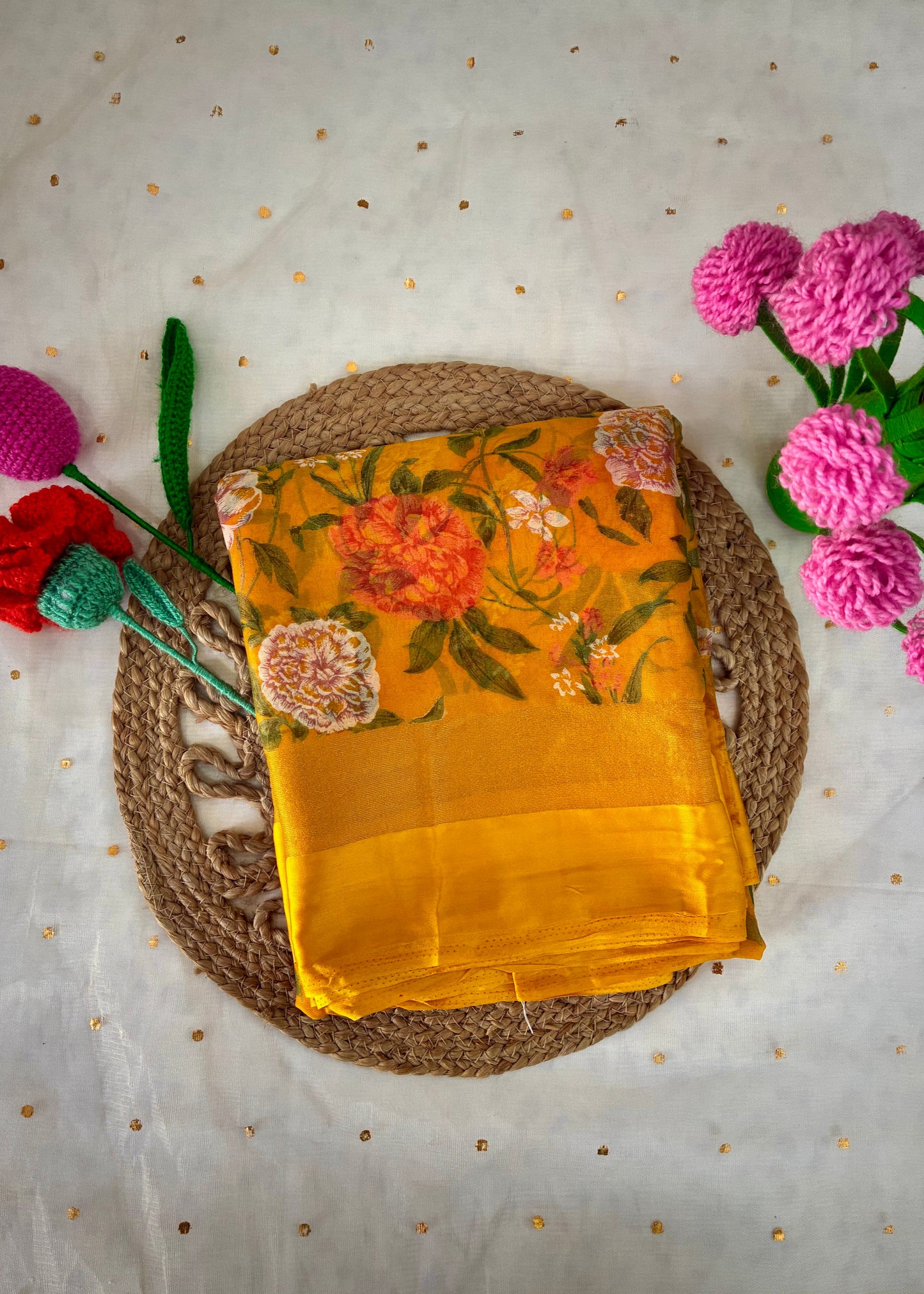 Yellow fabric with floral patterns on a textured surface with flowers around