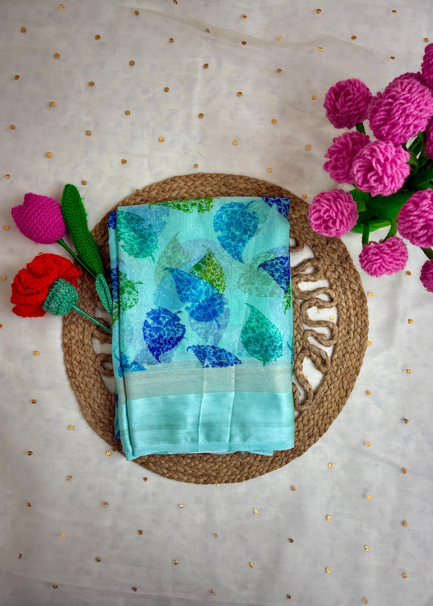 Teal fabric with blue floral pattern on a woven mat with flowers