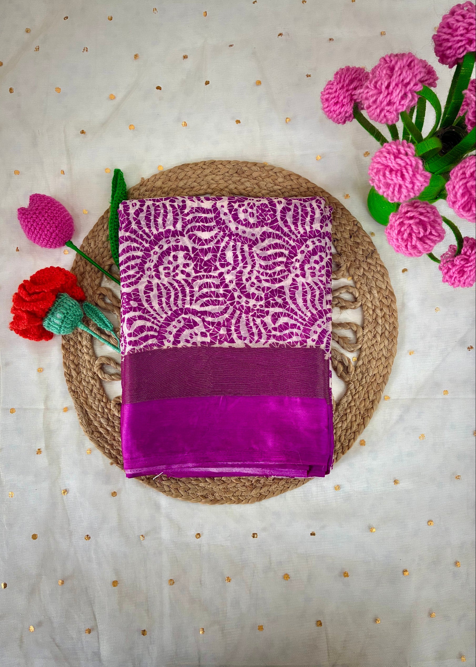 Purple saree with white pattern on a textured surface with flowers