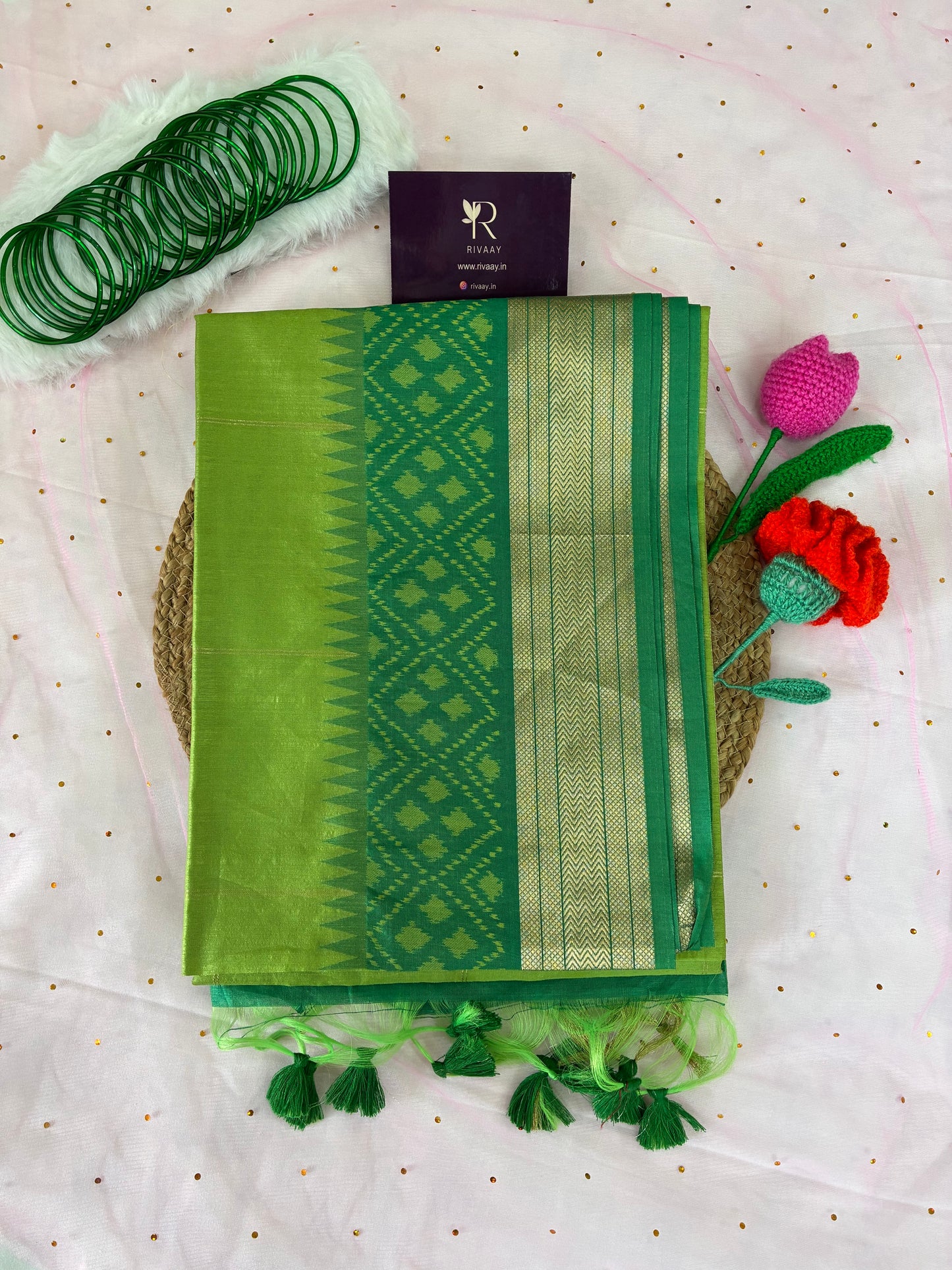 Green fabric pouch with decorative elements on a white background