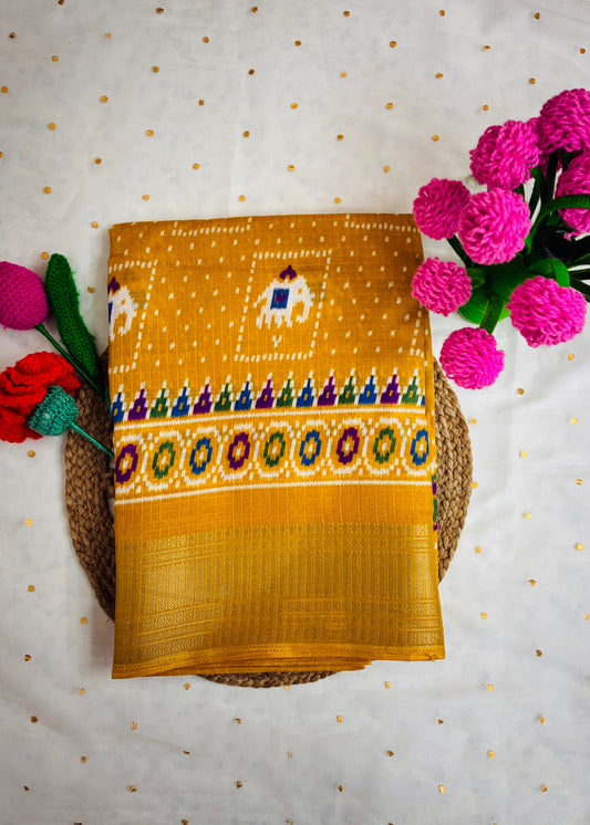 Yellow fabric with colorful patterns on a textured surface with pink flowers.