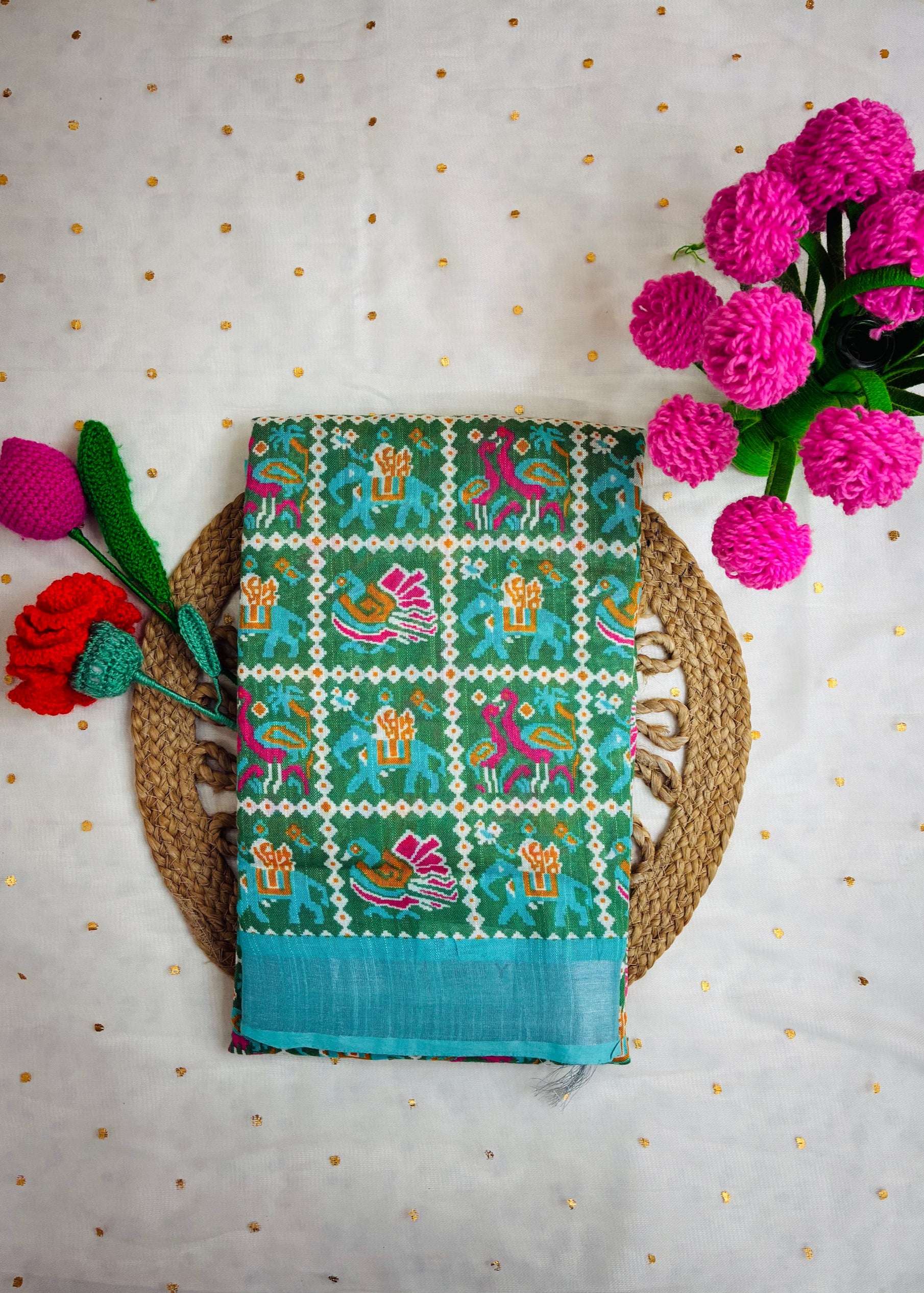 Saree with colorful patterns on a textured surface with flowers.