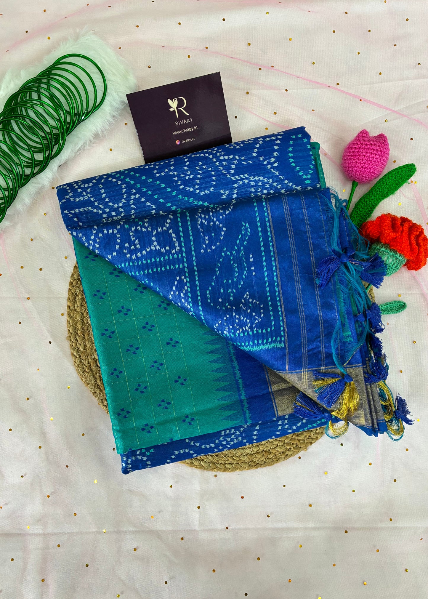 Blue and green fabric with decorative elements on a textured white background