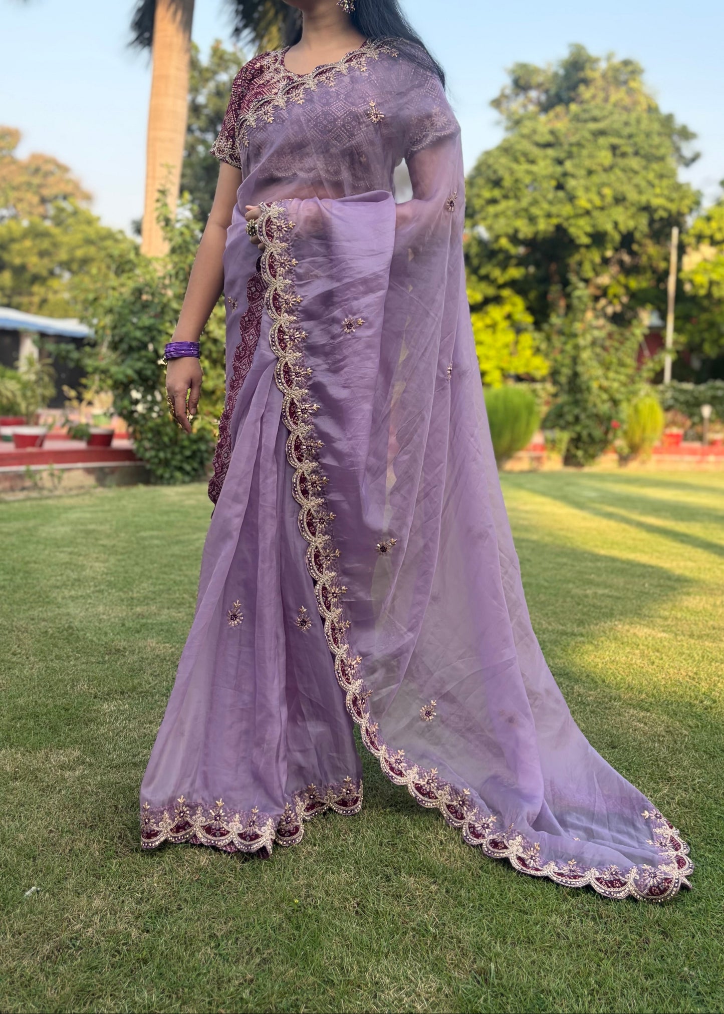 Woman in a lavender saree with a garden background