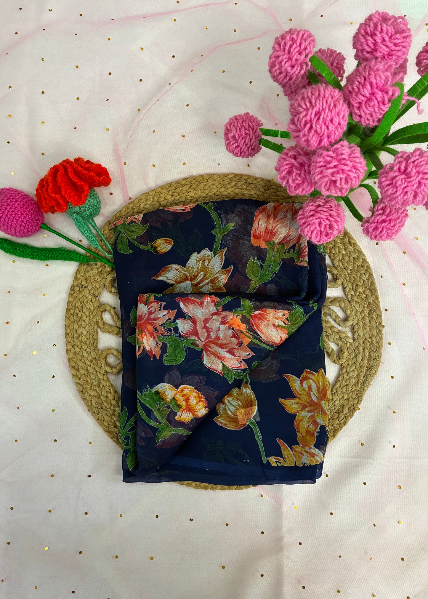 Floral-patterned fabric on a woven mat with pink and red flowers on a white background
