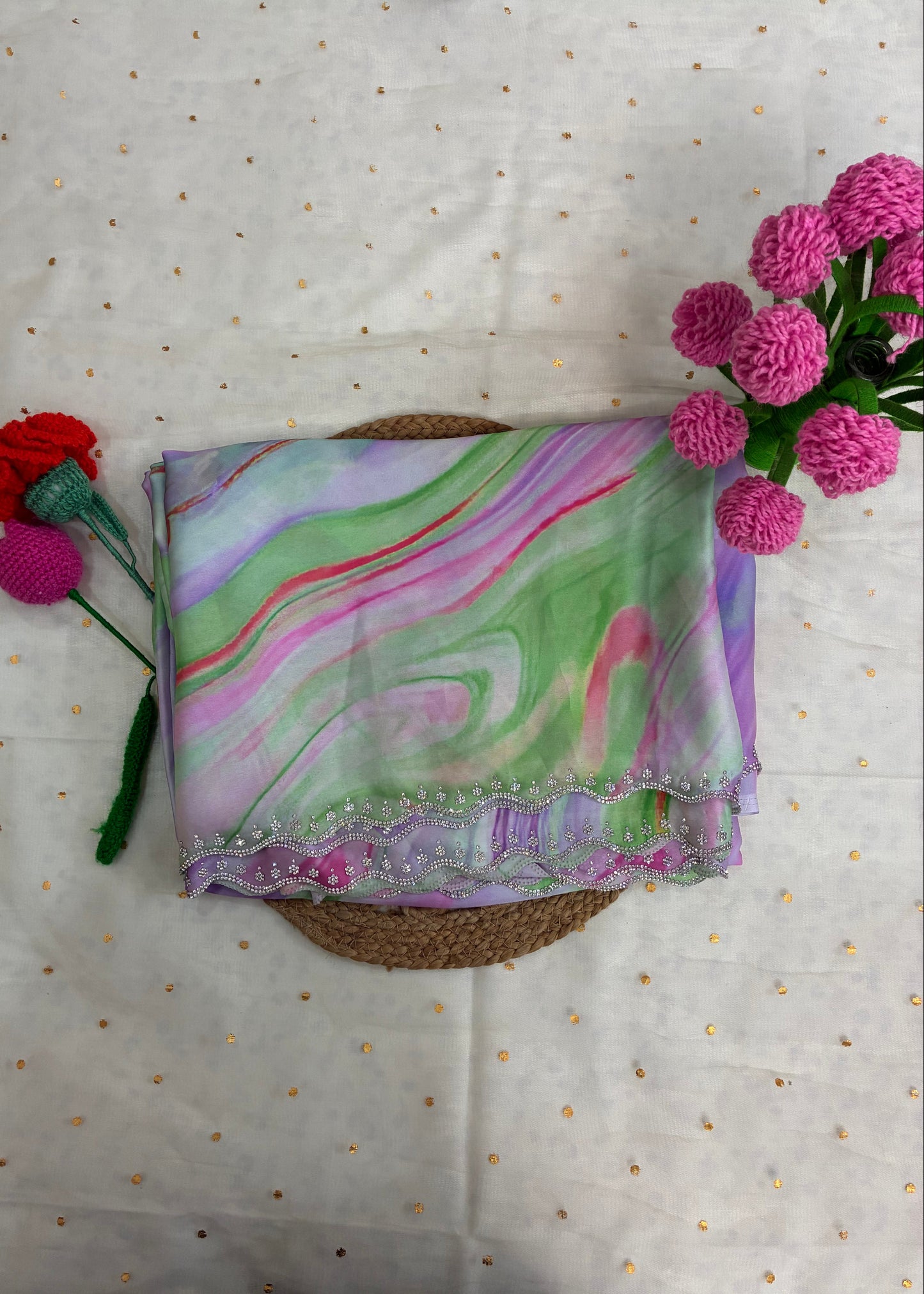 Marbled fabric with colorful patterns on a textured surface with flowers.