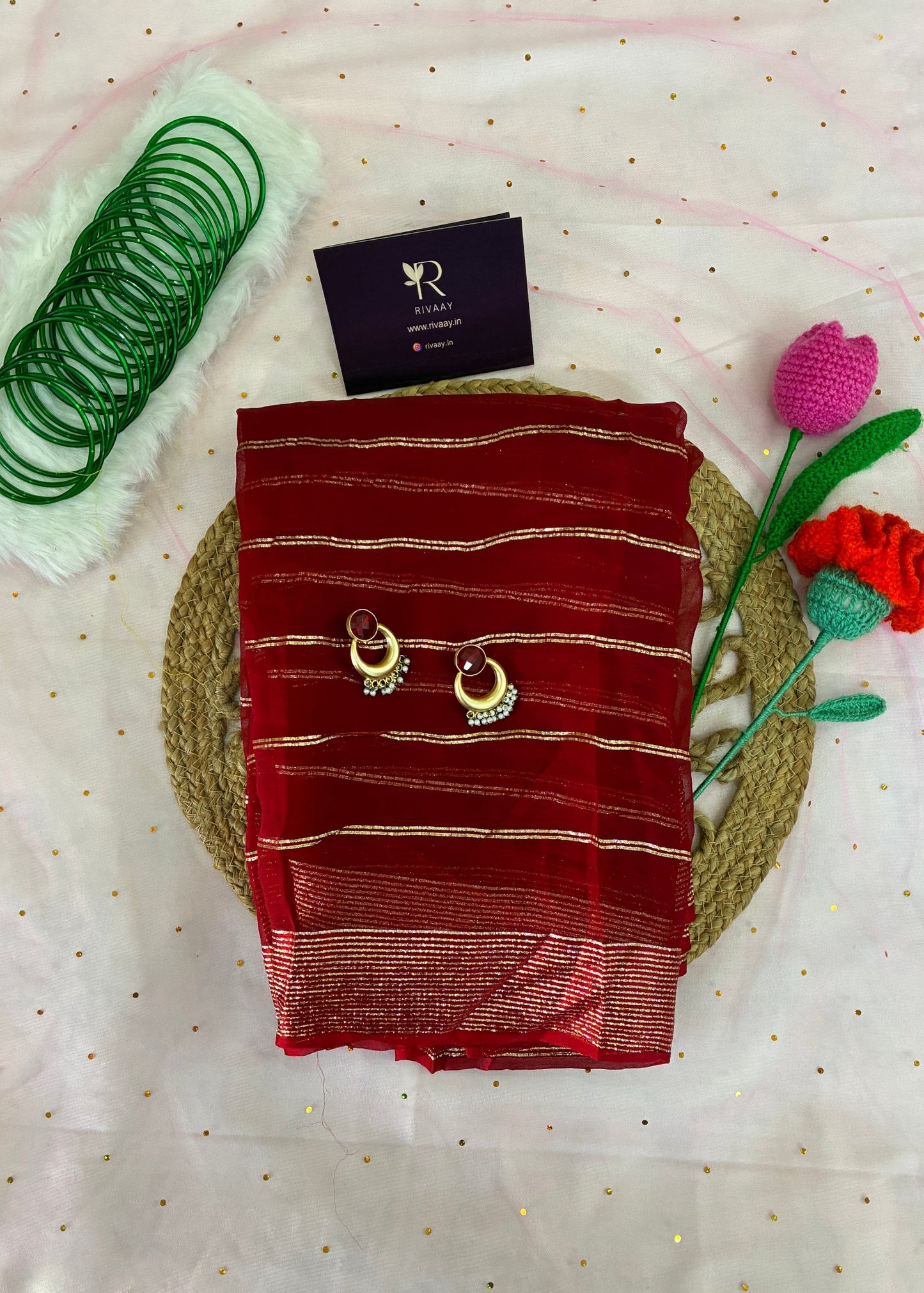 Red saree with gold patterns on a white fabric background