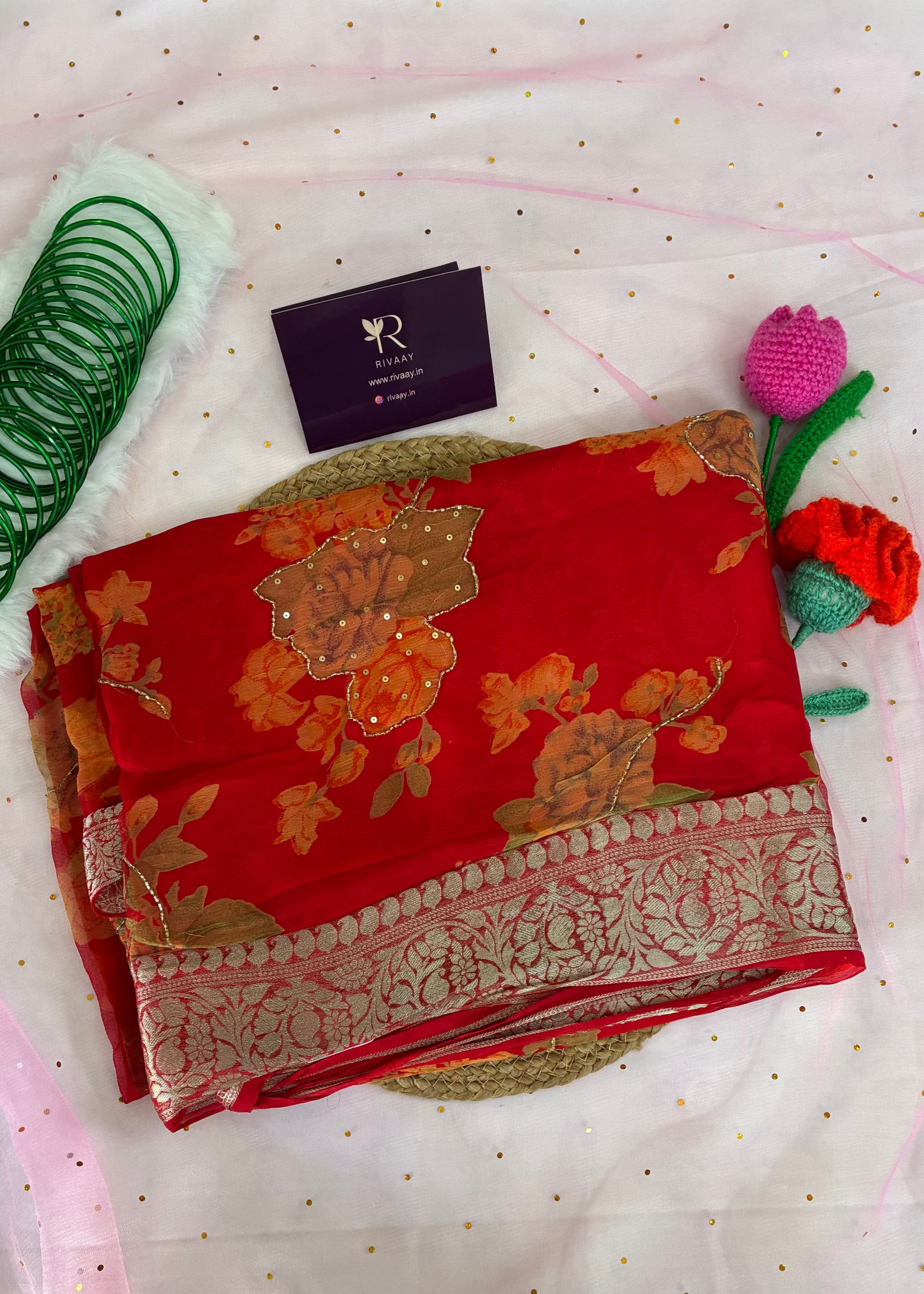 Red saree with floral patterns on a white background